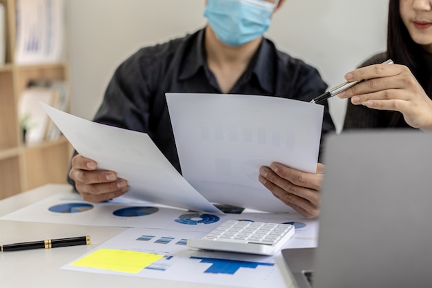 Vergaderruimte van een startend bedrijf waar twee zakenlieden financiële informatie uit documenten bekijken, ze ontmoeten elkaar over maandelijkse financiële onderwerpen. Concept van financieel beheer.