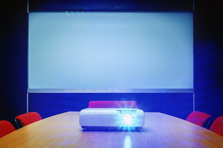 Foto vergaderzaal met blauw licht van projector op de tafel