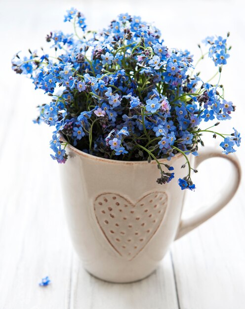 Vergeet me geen bloemen in een kopje op tafel