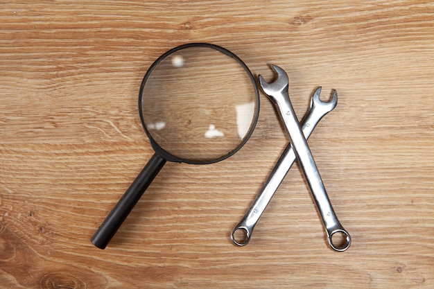 Foto vergrootglas en moersleutels op tafel. concept zoeken technische ondersteuning