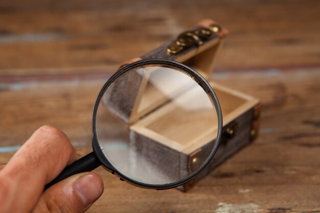 Vergrootglas kijkt naar de oude kist op tafel