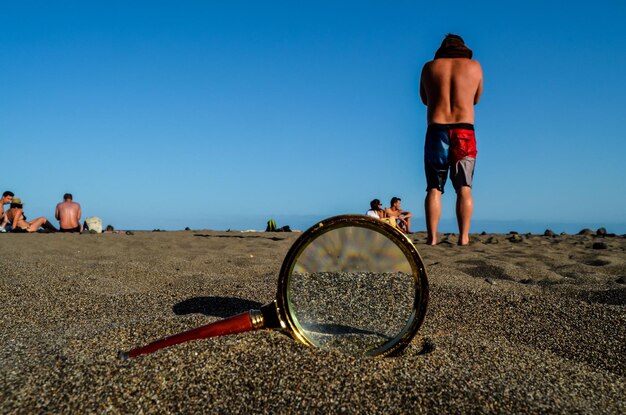 Vergrootglas op het zandstrand