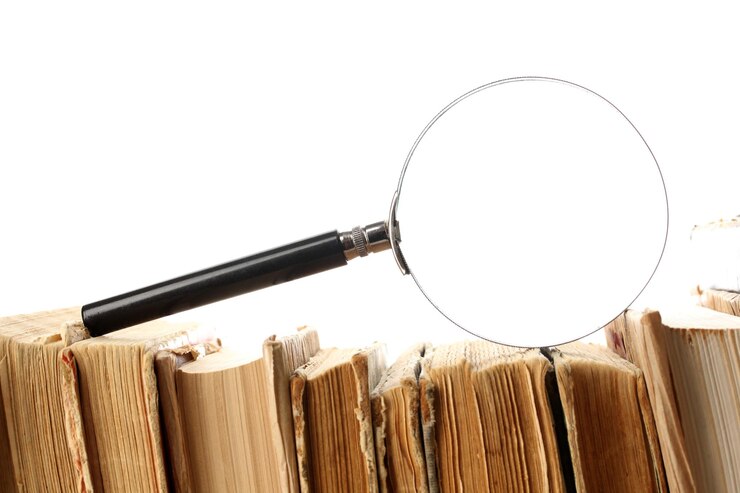 Foto vergrootglas over de stapel boeken geïsoleerd op wit