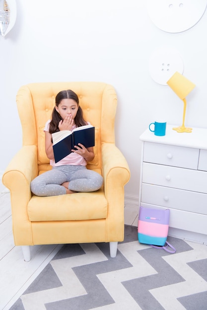 Verhaalconcept Klein meisje leest verhaal in stoel Kind leest verhalenboek Verhaaltijd Er was eens