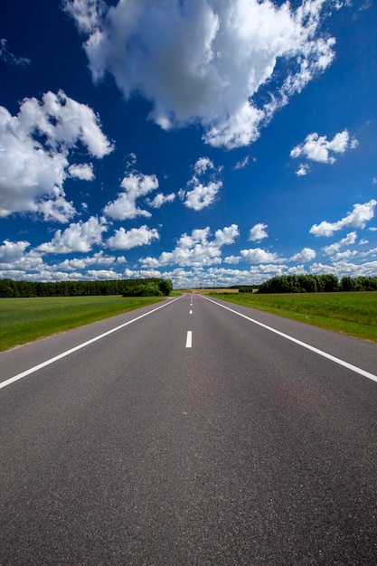 Verharde snelweg met blauwe lucht en wolken