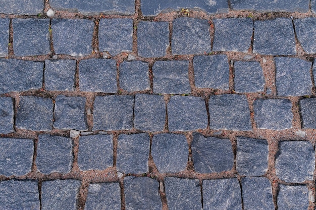 Verharde weg voor achtergrond en textuur een oude weg gemaakt van granieten straatstenen