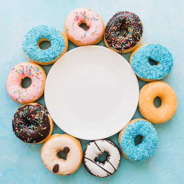 Foto verhoogde weergave van plaat omgeven door verschillende verse donuts