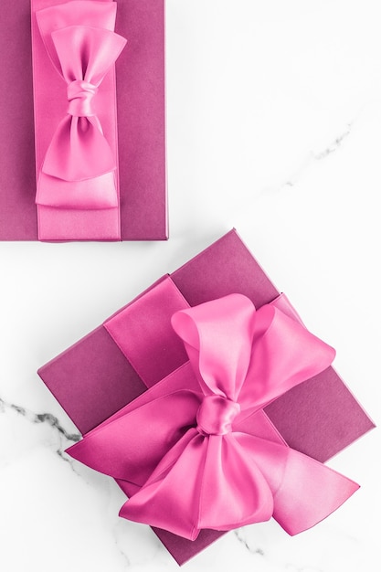 Verjaardag bruiloft en girly branding concept roze geschenkdoos met zijden strik op marmeren achtergrond meisje baby shower aanwezig en glamour mode cadeau voor luxe schoonheid merk vakantie flatlay art design