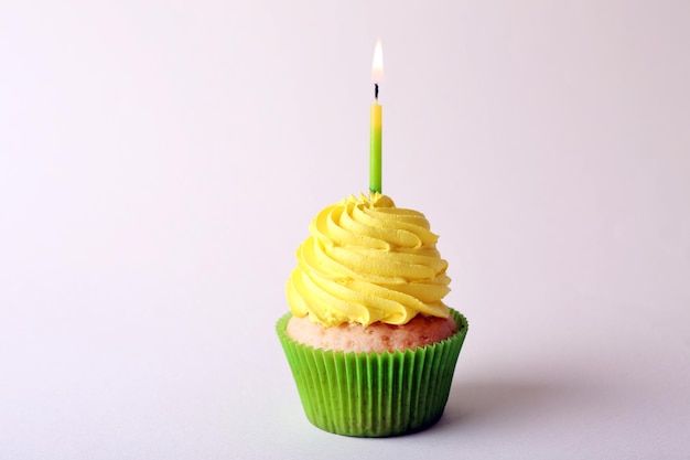 Verjaardag cupcake met kaars op kleur achtergrond