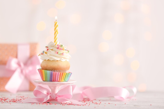 Verjaardag cupcake met kaars op tafel tegen wazig licht