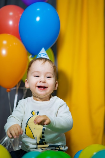 Verjaardag jong kind met hoed en ballonnen Grappige schattige babyviering