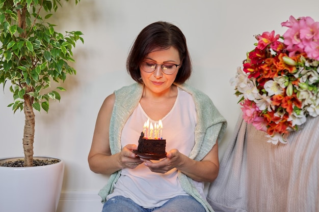 Verjaardag viering verjaardag 45 jaar oude vrouw met kleine taart met brandende kaarsen