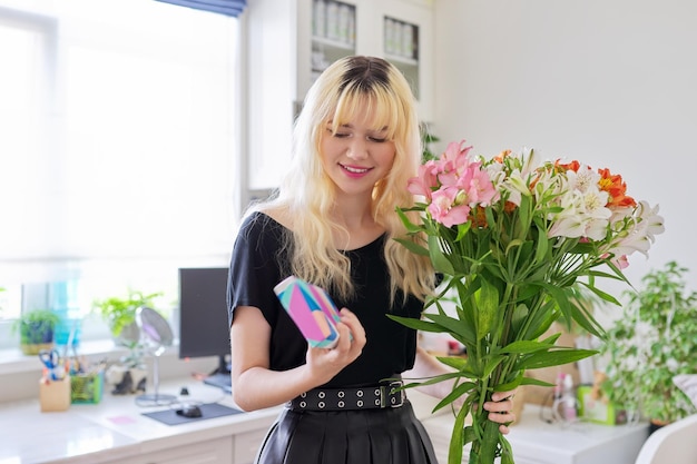 Verjaardagsfeestje vrouwelijke tiener met boeket bloemen en verrassingsgeschenkdoos