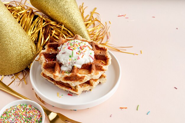 Verjaardagsfeestwafels versierd met yoghurt en kleurrijke hagelslag