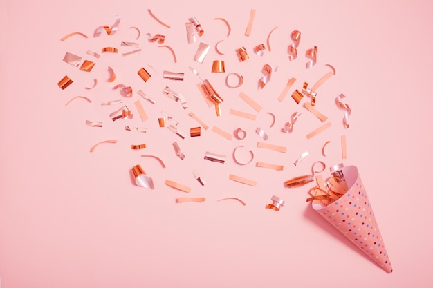 Verjaardagshoed met confetti op roze achtergrond