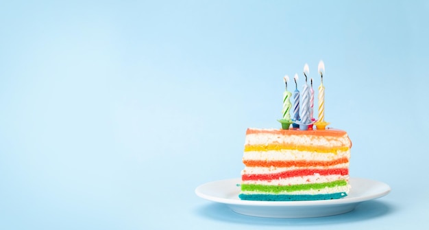 Verjaardagstaart met brandende kaarsen op een blauw