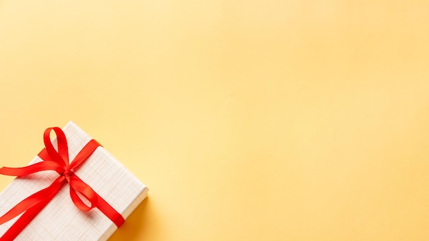 Verjaardagsverrassing Feestelijke achtergrond Huidige doos geplakt door rood lint geïsoleerd op beige kopie ruimte Groet uitnodiging Vakantie felicitatie