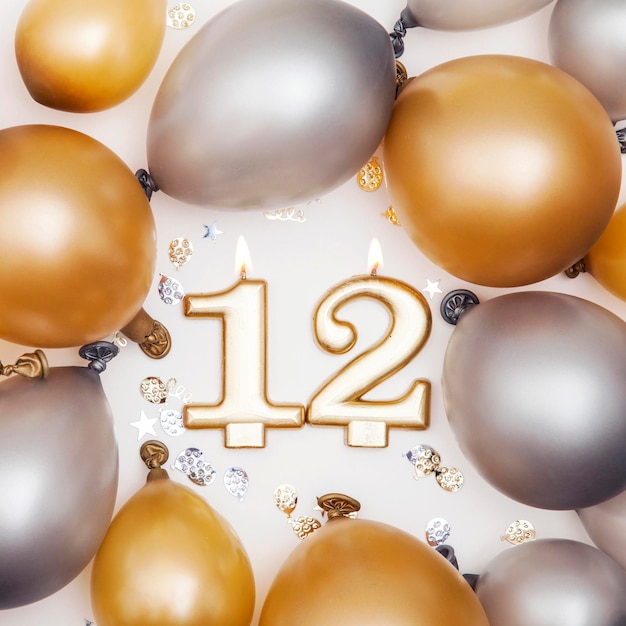 Verjaardagsviering nummer 12 kaars met gouden en zilveren ballonnen