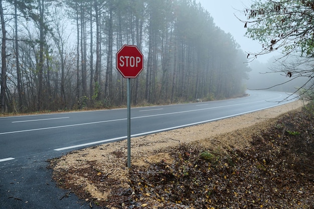 Verkeersbord stopt bij de bosweg in de mist