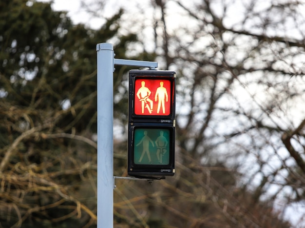 Foto verkeerslicht in rood met twee personen en een fiets in wenen.