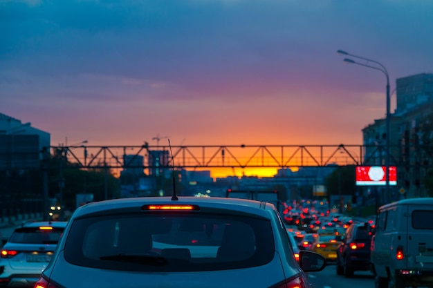 Verkeersopstoppingen op de weg's avonds bij zonsondergang in de zomer Rode lichten van koplampen