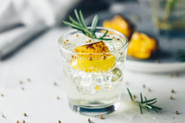 Foto verkoolde citroen rozemarijn en koriander gin en tonic is een smaken zijn perfect evenwichtig verfrissende cocktail op lichte achtergrond close-up zomer dranken en alcoholische cocktails