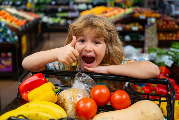 Verkoop consumentisme en kind opgewonden klein kind met eten in winkelwagentje bij supermarkt kleine chi