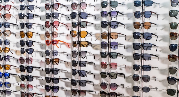 Verkoop rek van zonnebrillen. Een kleurrijke display van zonnebrillen te koop. Detailopname.
