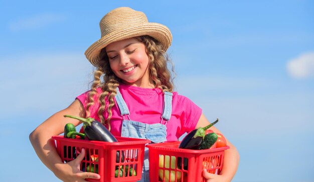 Verkoop van zelfgekweekte voedselconcept Natuurlijke vitaminevoeding Biologische groenten Meisje schattig kind landbouw Het verzamelen van groenten in mand Dorp rustieke stijl Groentenmarkt Zonnige dag op boerderij