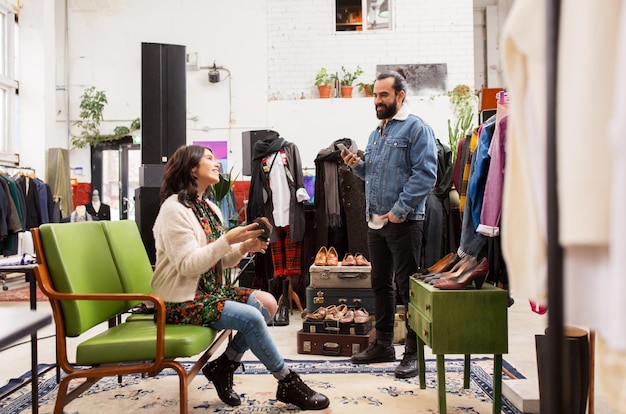 verkoop winkelen schoenen en mensen concept gelukkig paar het kiezen van loafer schoenen in vintage kledingwinkel