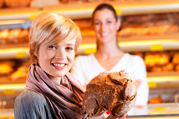 Verkoper met vrouwelijke klant in bakkerij