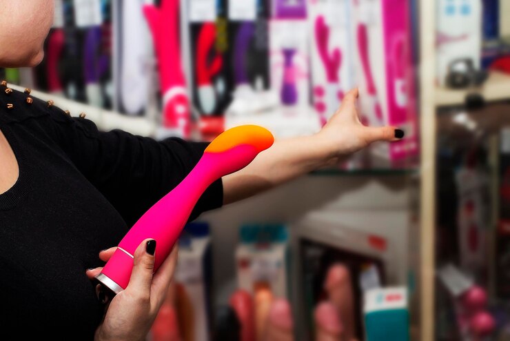 Verkoper van sekswinkel toont seksspeeltje