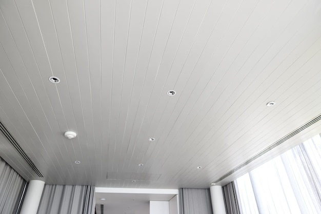 Verlaagd plafond met halogeenspots lampen en gipsplaten constructie in lege ruimte in appartement of huis Spanplafond wit en complexe vorm