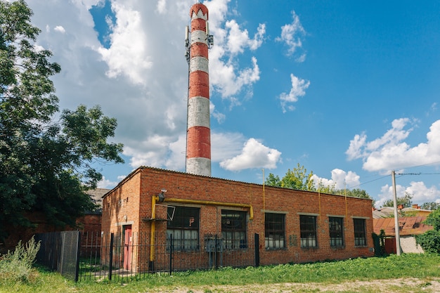 Verlaten fabriek of fabriek van rode bakstenen met lange uitlaatpijp