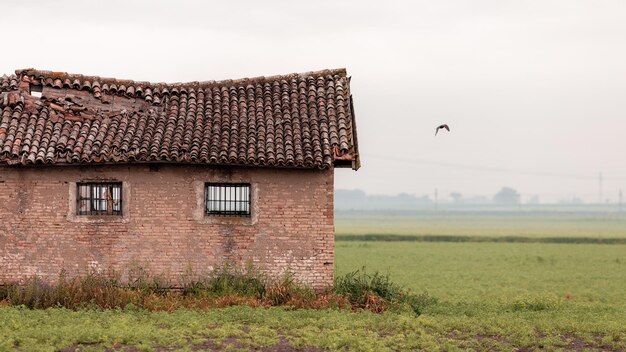 Verlaten huis op het veld tegen de lucht