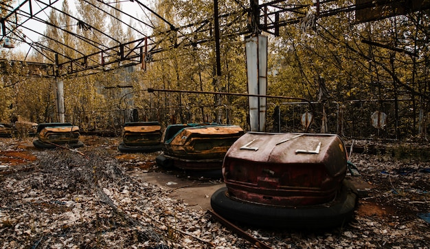 Verlaten pretpark met roestige auto's in Pripyat-stad bij de uitsluitingsstreek van Tsjernobyl.