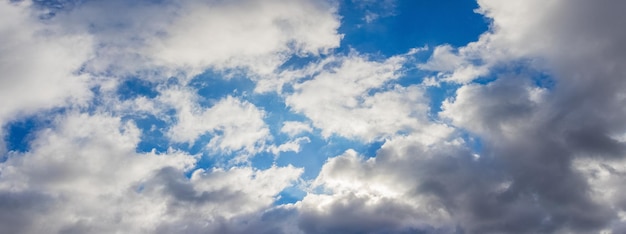 Verlicht door de zon witte en grijze wolken in de blauwe lucht