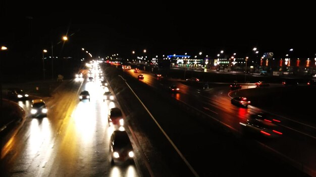 Foto verlichte auto's op straat tegen een heldere hemel's nachts