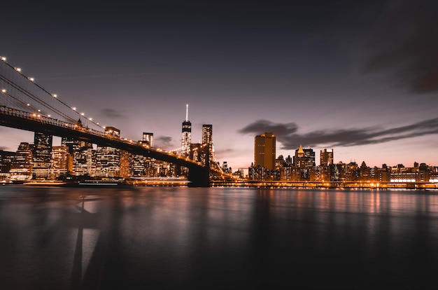 Verlichte brooklyn brug over de oostelijke rivier in de stad tegen de hemel's nachts