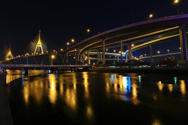 Verlichte brug over de rivier met de stad op de achtergrond
