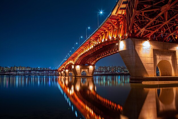 Foto verlichte brug over de rivier's nachts