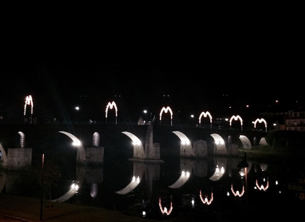 Foto verlichte brug over de rivier's nachts
