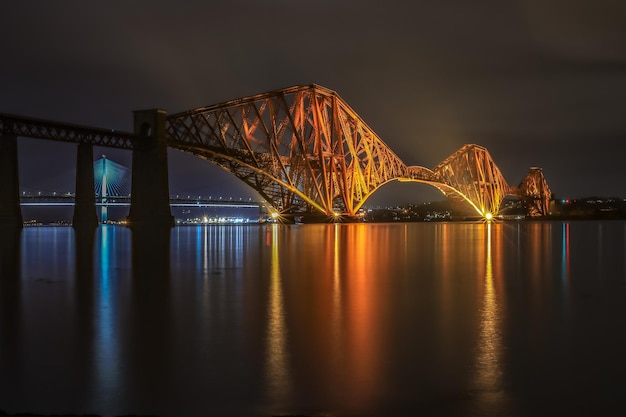 Foto verlichte brug over de rivier 's nachts
