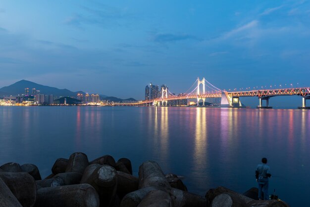 Foto verlichte brug over de zee tegen de hemel in de schemering