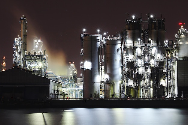 Verlichte fabriek tegen de hemel's nachts.