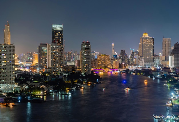 Verlichte gebouwen en rivier in de stad's nachts