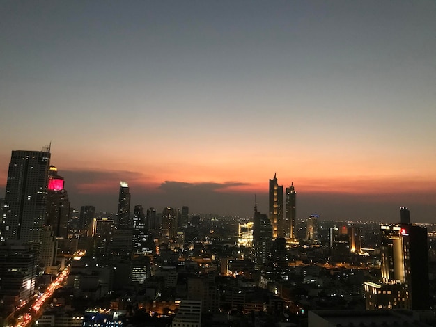 Foto verlichte gebouwen in de stad tegen de hemel bij zonsondergang