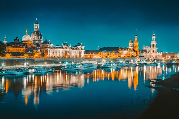 Verlichte gebouwen langs de rivier in de stad's nachts