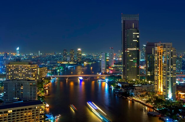 Foto verlichte gebouwen langs de rivier tegen de hemel's nachts