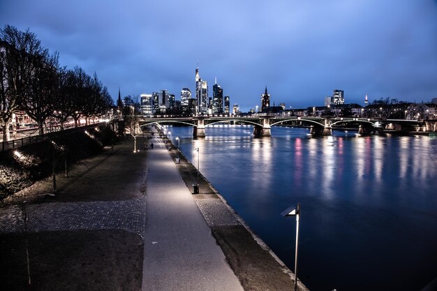 Verlichte gebouwen langs de rivier tegen de lucht in de stad